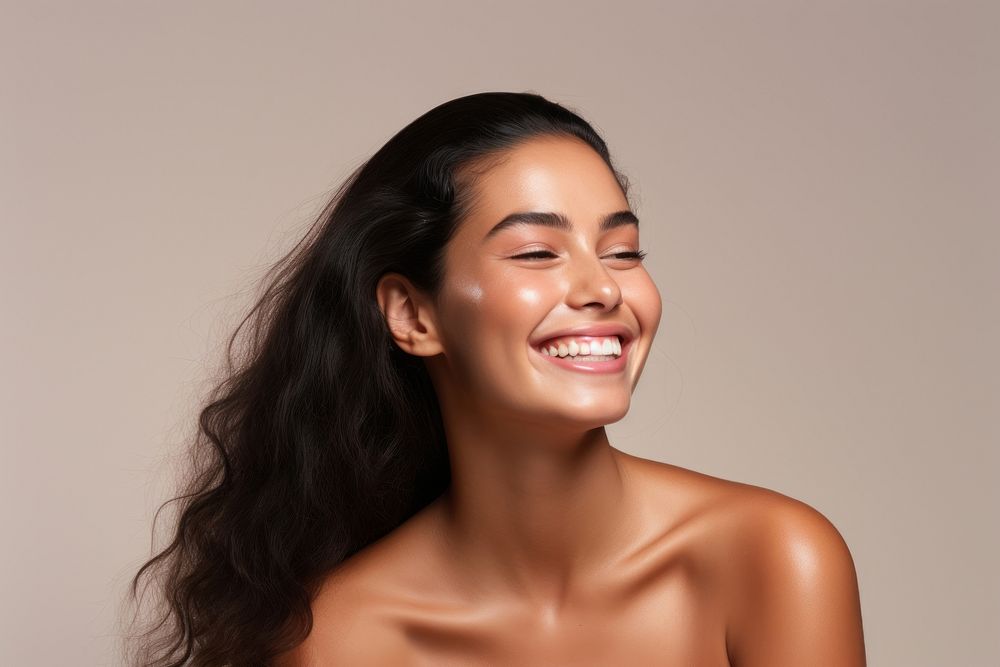 A firm Pacific Islander womans with cosmetic product laughing adult smile.