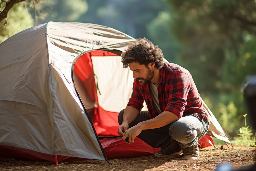 Hispanic man outdoors camping tent.