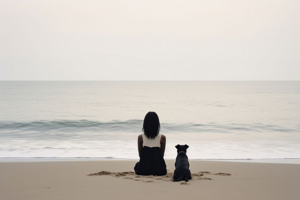 Woman and white dog sitting at beach silhouette outdoors horizon.