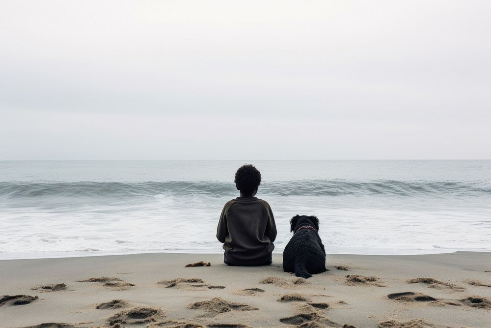 Kid and dog sitting at beach outdoors vacation horizon.