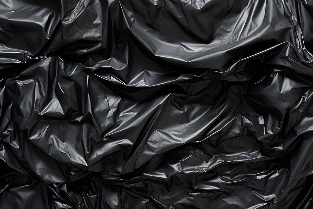 Black crumpled plastic bag backgrounds monochrome abundance. AI generated Image by rawpixel.