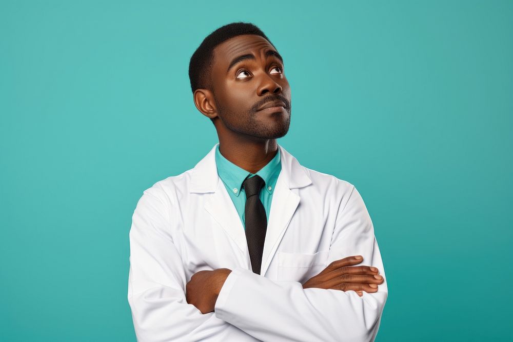 African Male doctor looking up with arms crossed adult male stethoscope.