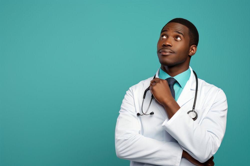 African Male doctor looking up with arms crossed adult male stethoscope.