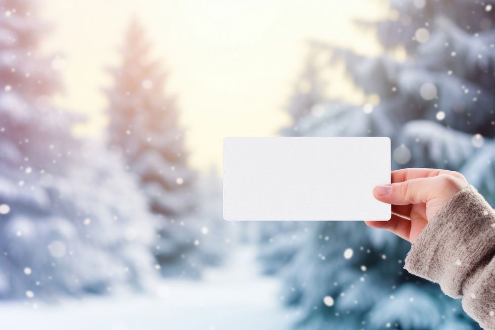 Hand holding blank name card christmas outdoors nature.