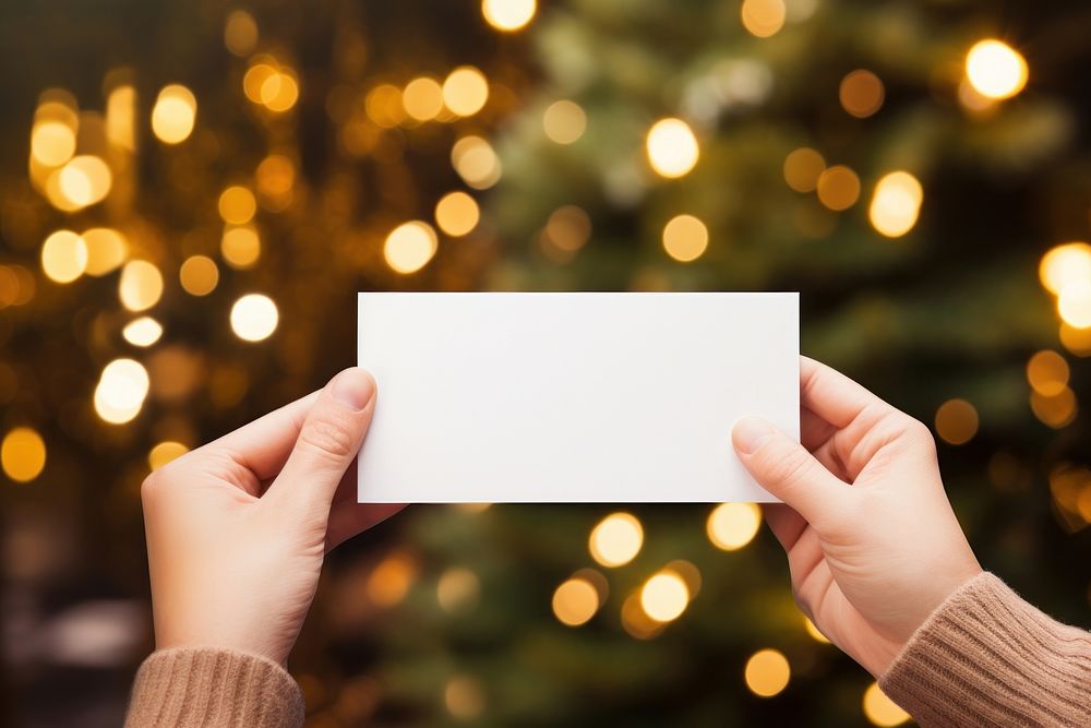 Hand holding blank name card christmas paper tree.