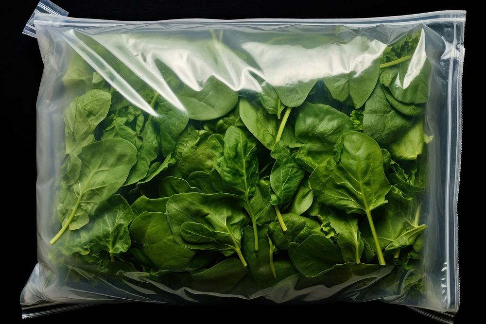 Plastic wrapping over food packaging vegetable spinach plant.