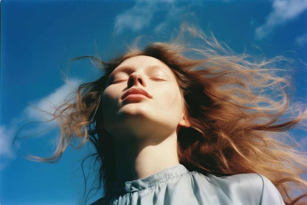 A close up of a person with their eyes closed photo blue sky. AI generated Image by rawpixel.