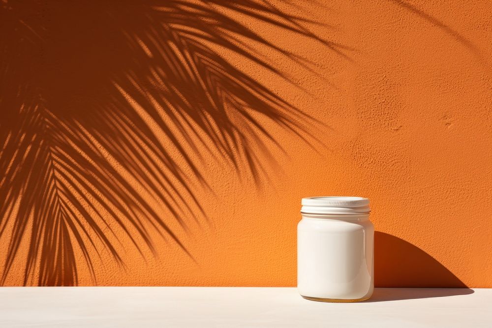 White jam jar with orange plant wall container.