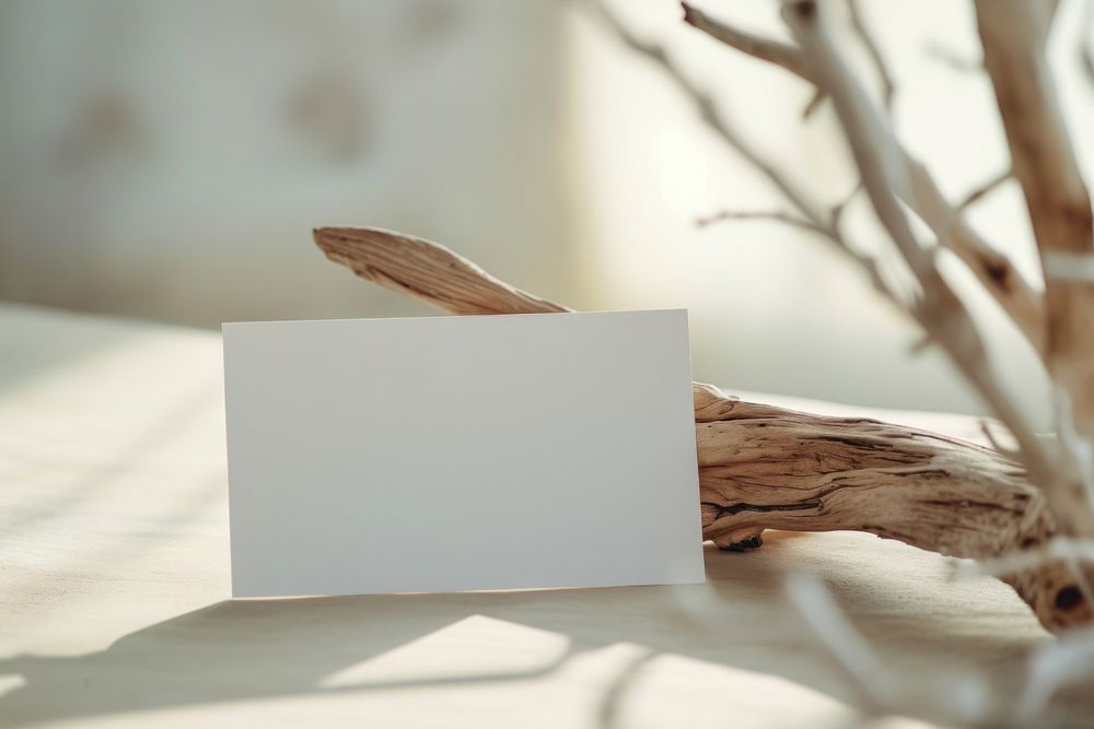 A paper card with driftwood document absence indoors.