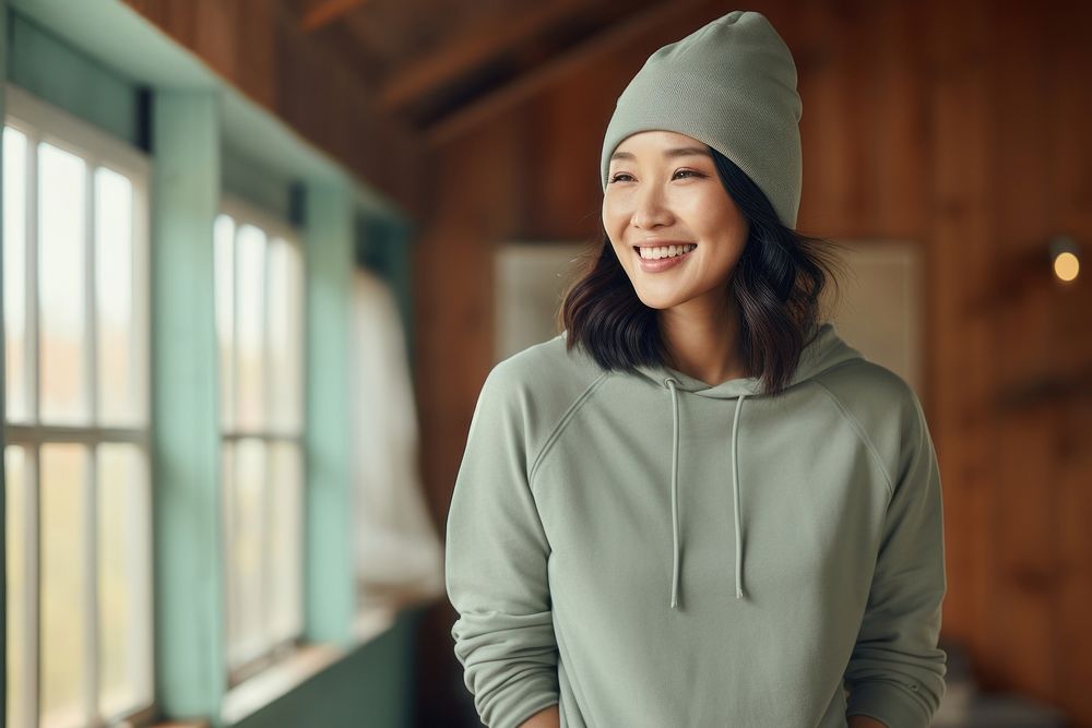 Happy asian american middle age woman wearing plain color hoodie architecture sweatshirt smile.