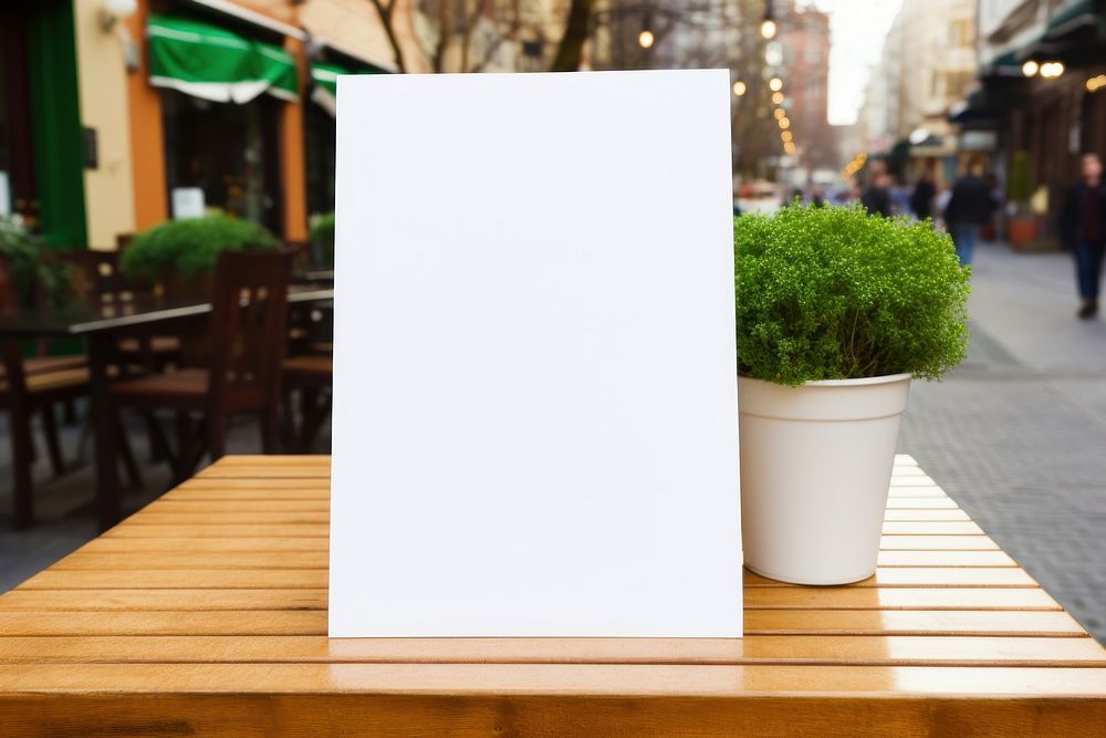 A white blank menu sign plant table text.