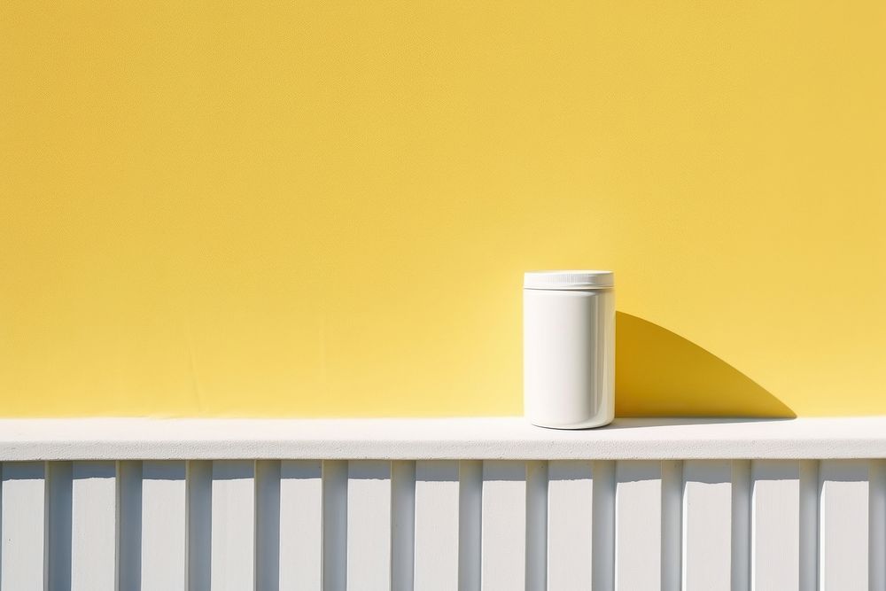 A white can onto a barricaded fence wall architecture yellow.