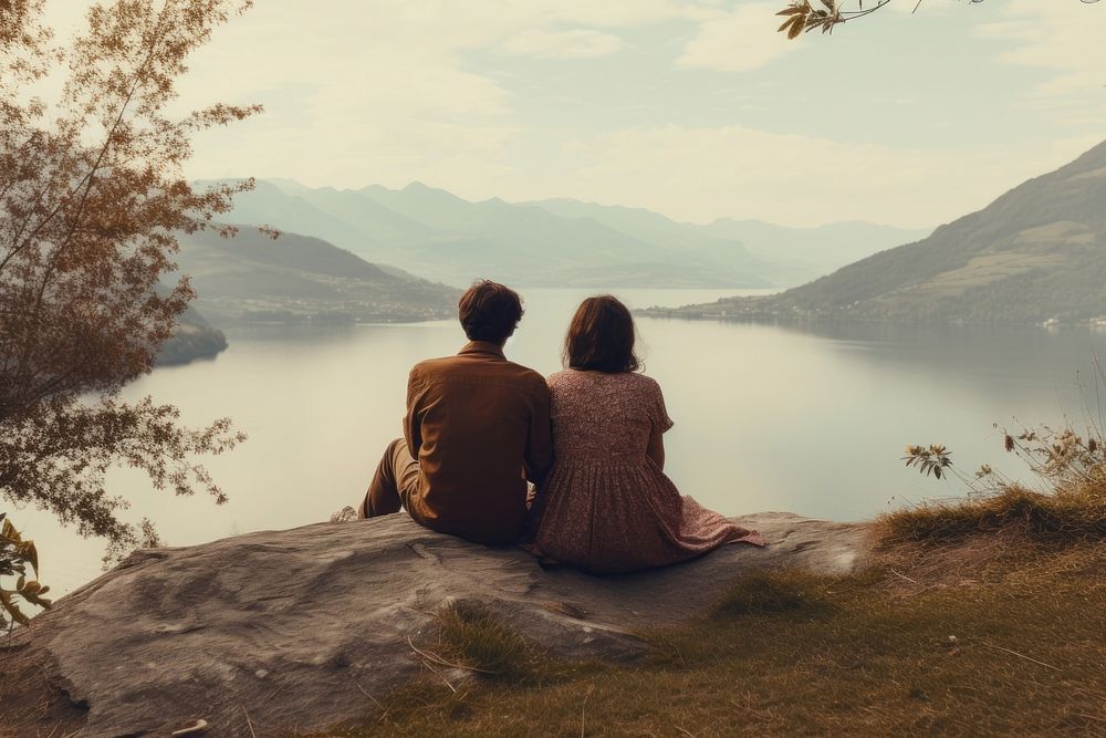 A couple sitting cutely on a mountain lake photography landscape.