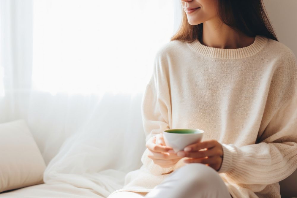 Woman holding a cup of matcha tea sweater sitting coffee. AI generated Image by rawpixel.