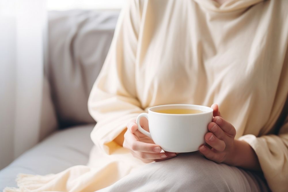 Woman holding a cup of tea sitting coffee drink. AI generated Image by rawpixel.