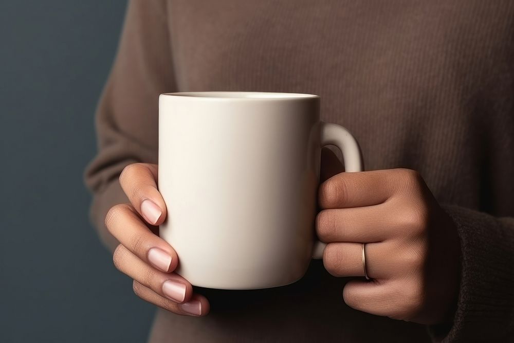 Person holding mug beverage coffee drink.