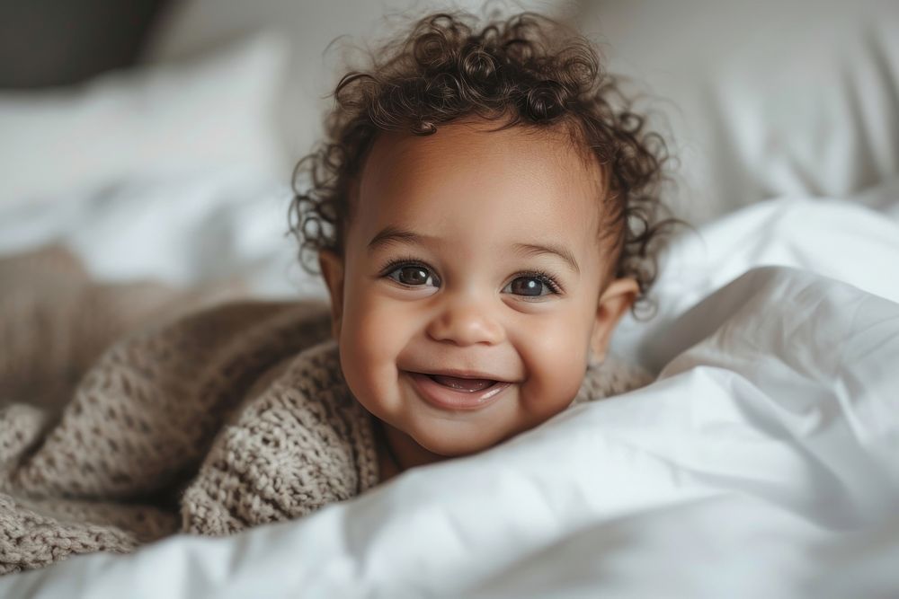 Mixed race baby girl smiling smile bed.