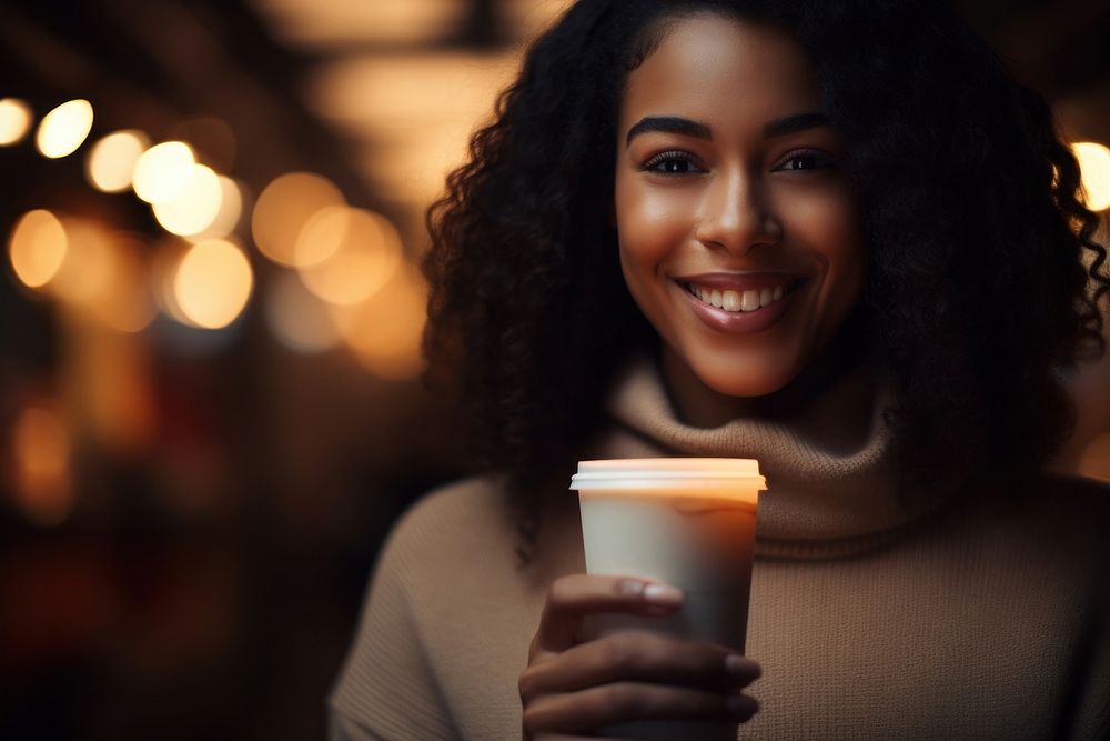 Black woman holding coffee drink.