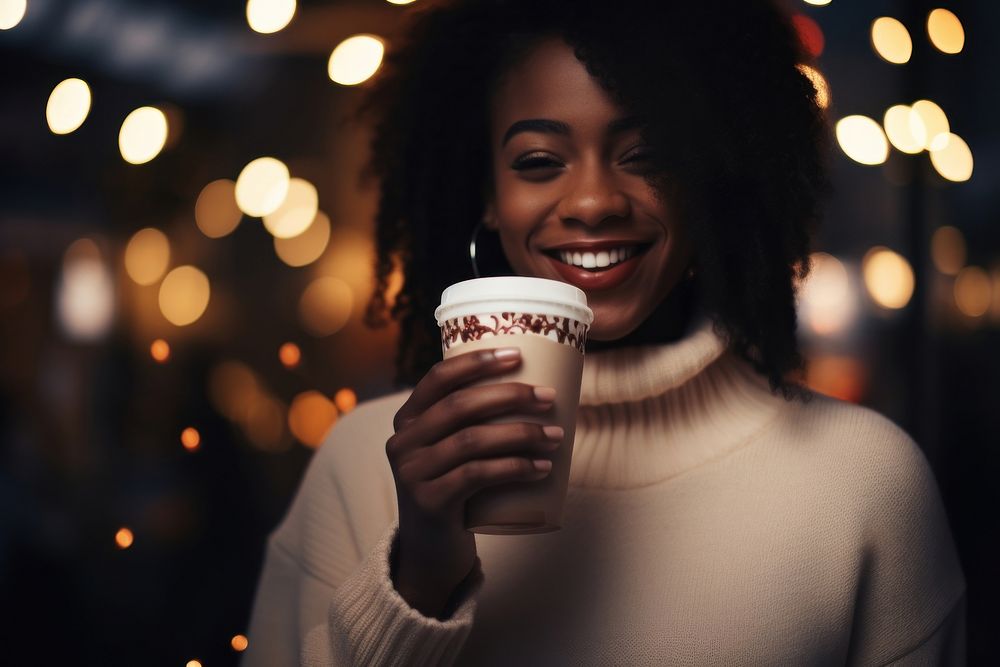 Black woman holding coffee drink.