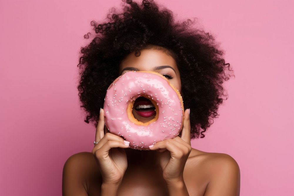 Black woman food biting donut.