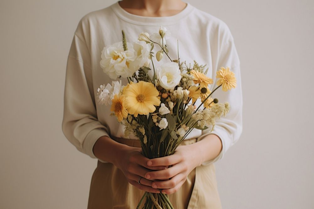 Person holding flowers plant inflorescence chrysanths.