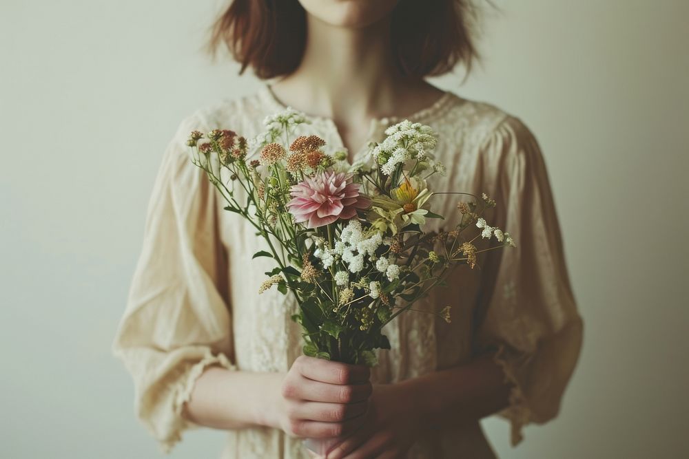 Person holding flowers plant adult dress.