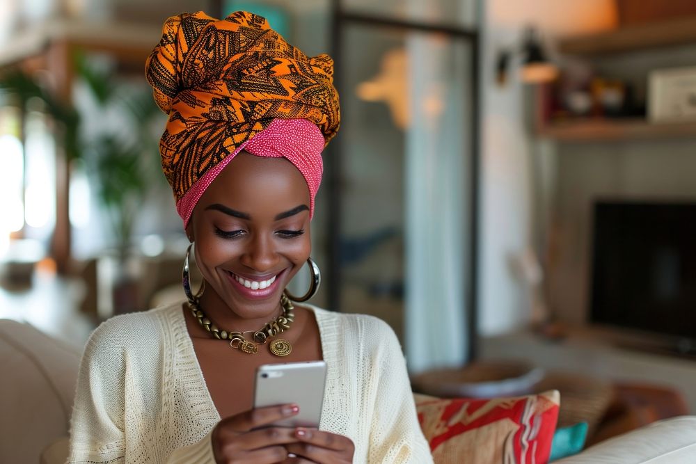 African turban using smartphone smiling smile celebration.