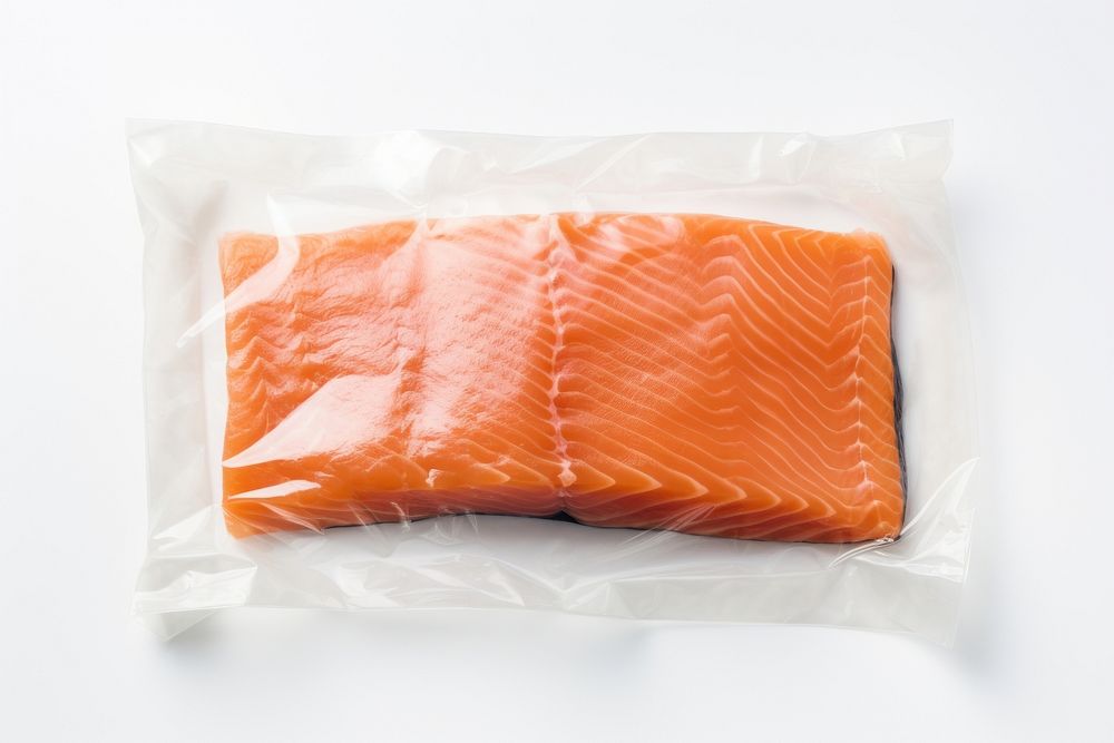 Plastic wrapping over a salmon fillet seafood white background freshness.