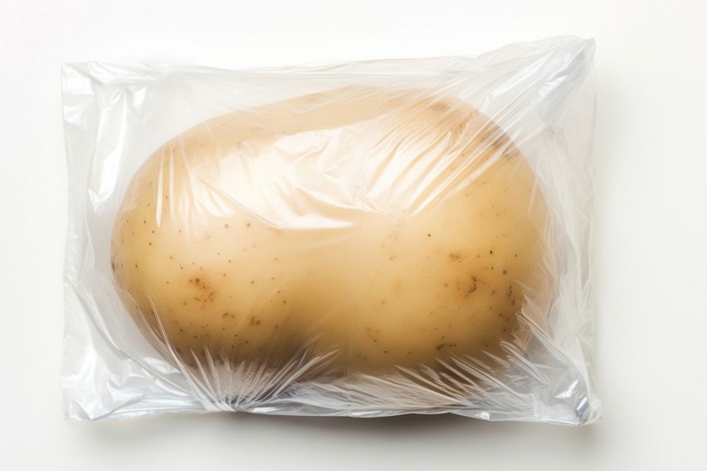 Plastic wrapping over a potato vegetable food white background.