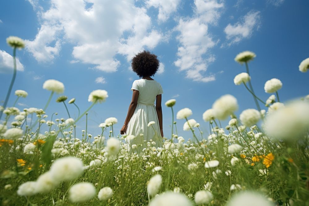 Photo of black woman in flower field summer grassland outdoors.