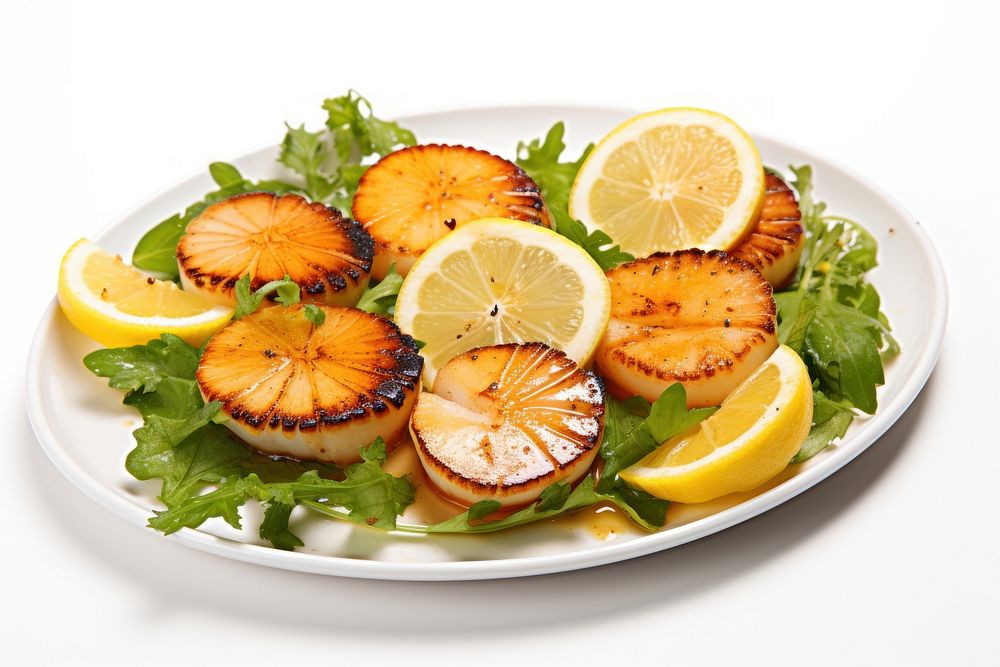 Grilled scallops with lemon slices and greens vegetable fruit plant.