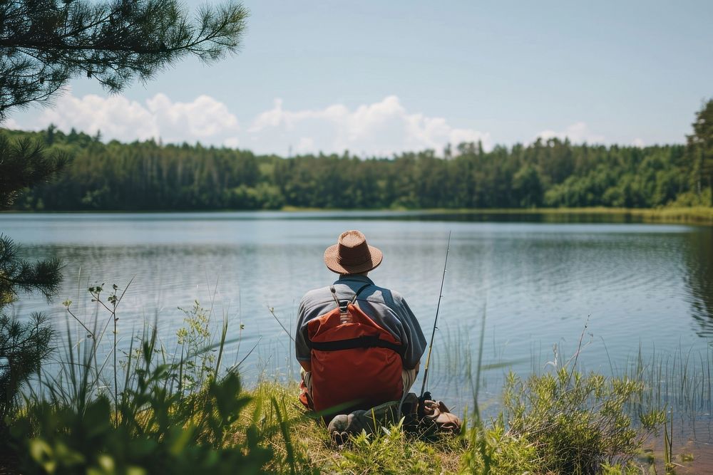 Photo of man fishing outdoors backpack sitting.
