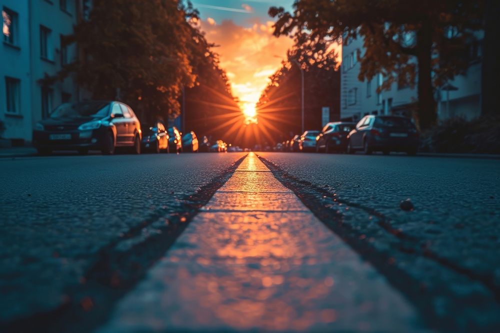 Photo of sunset behind a perspective street sky architecture sunlight.