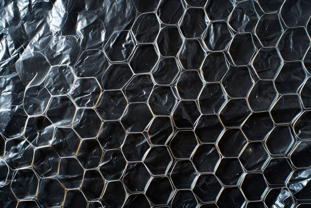 Plastic wrap with honeycomb patterns backgrounds texture black.