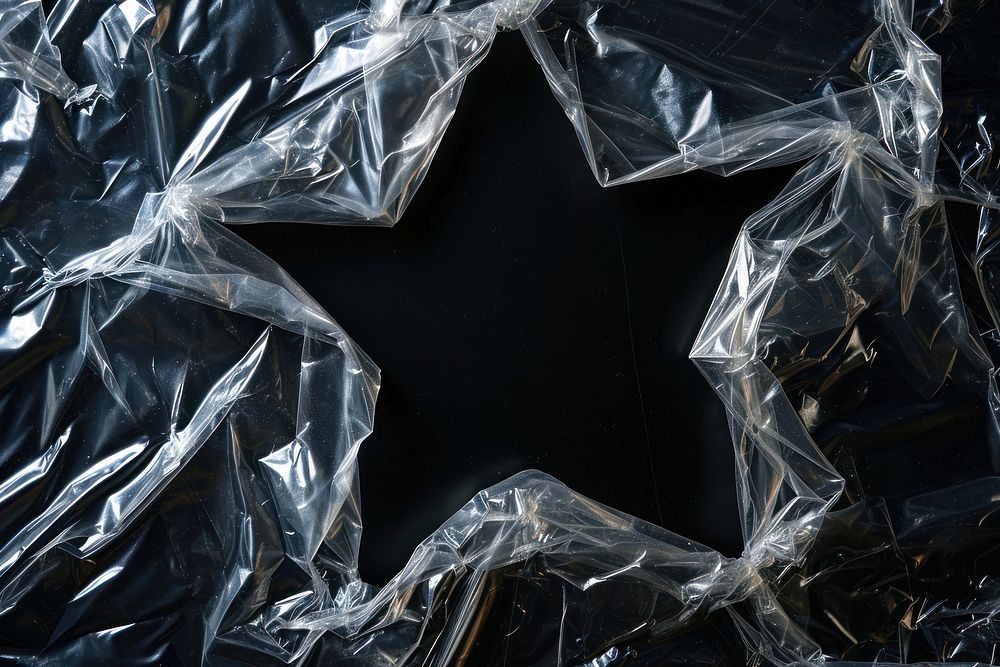Plastic wrap with star shaped hole backgrounds black monochrome.