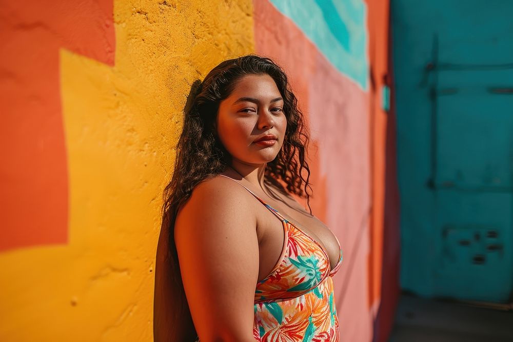 Chubby Latina woman in a swimming costume standing in front of a colorful wall portrait fashion adult. AI generated Image by…