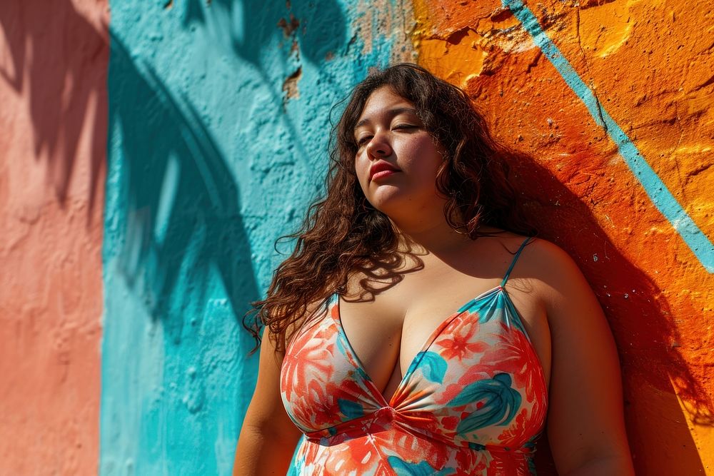Chubby Latina woman in a swimming costume standing in front of a colorful wall swimwear portrait fashion. AI generated Image…