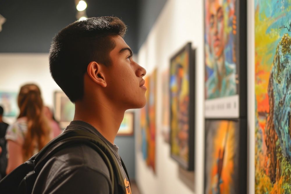 A Latino student showcasing artwork in a high school summer art exhibition creativity painting photo. AI generated Image by…