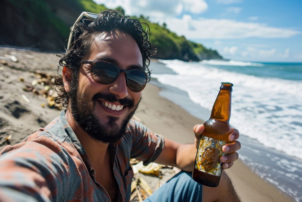 Selfie Latino man holding a beer bottle on a beach portrait relaxation drinking. AI generated Image by rawpixel.