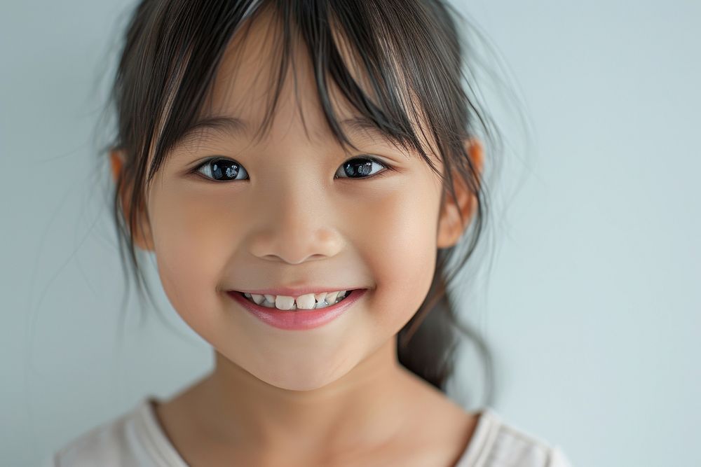 Close up little south east asian girl no make up smile child skin.