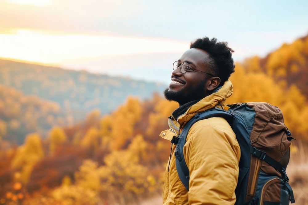 African man hiking mountain backpack autumn.