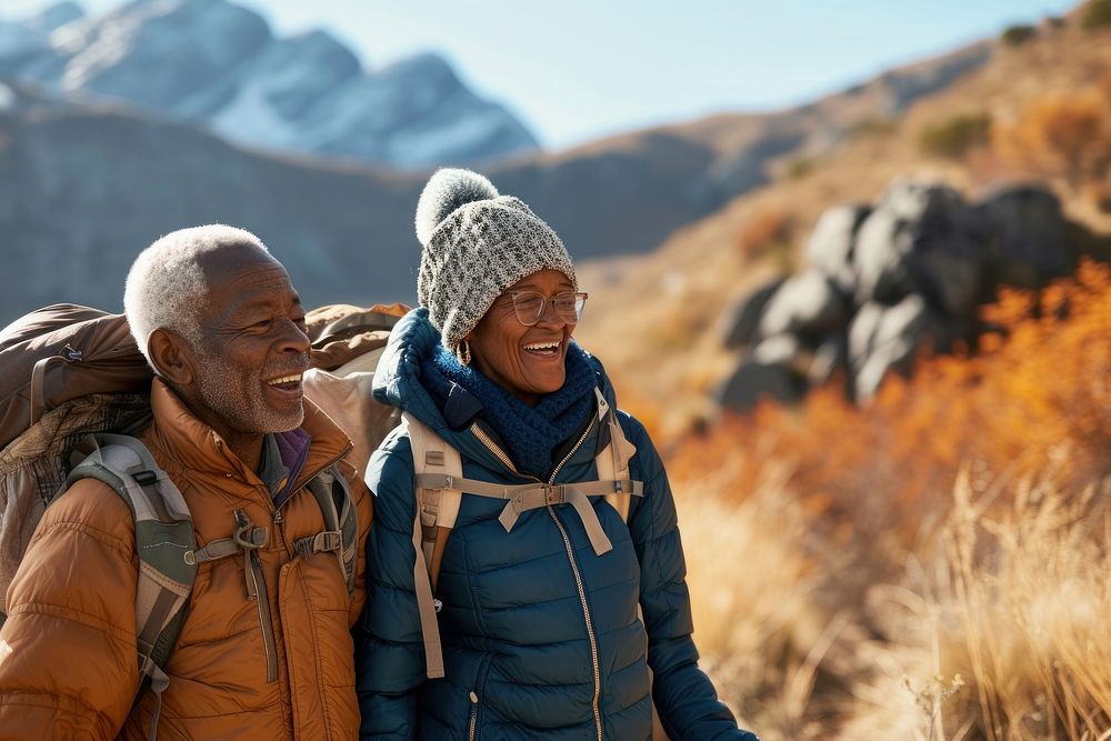 African senior couple hiking mountain backpack autumn.
