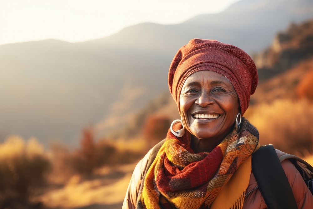 African senior woman hiking mountain smiling autumn.