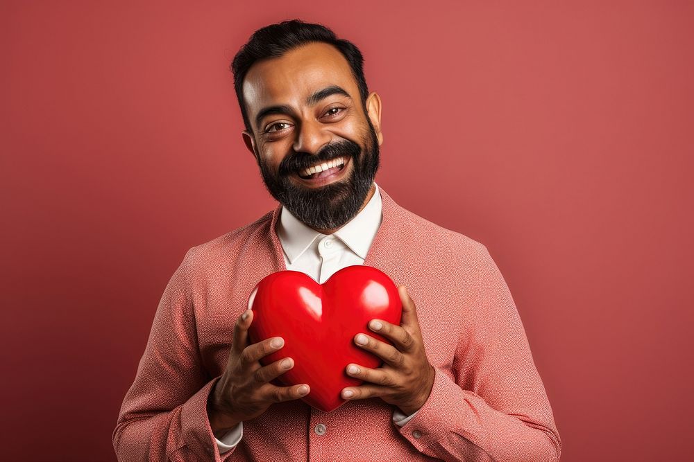 Indian male holding a heart sports love celebration.