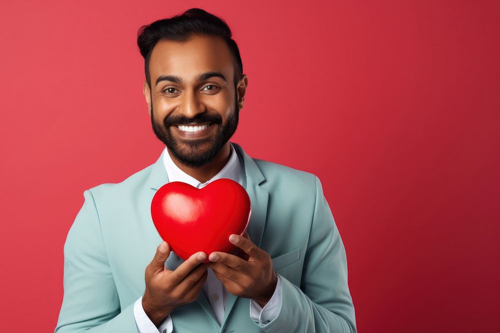 Indian male holding a heart balloon smile adult.