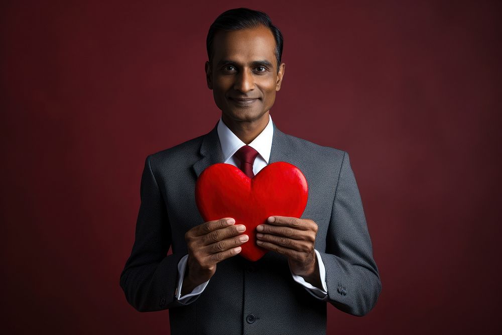 Indian man holding red heart adult tie celebration.