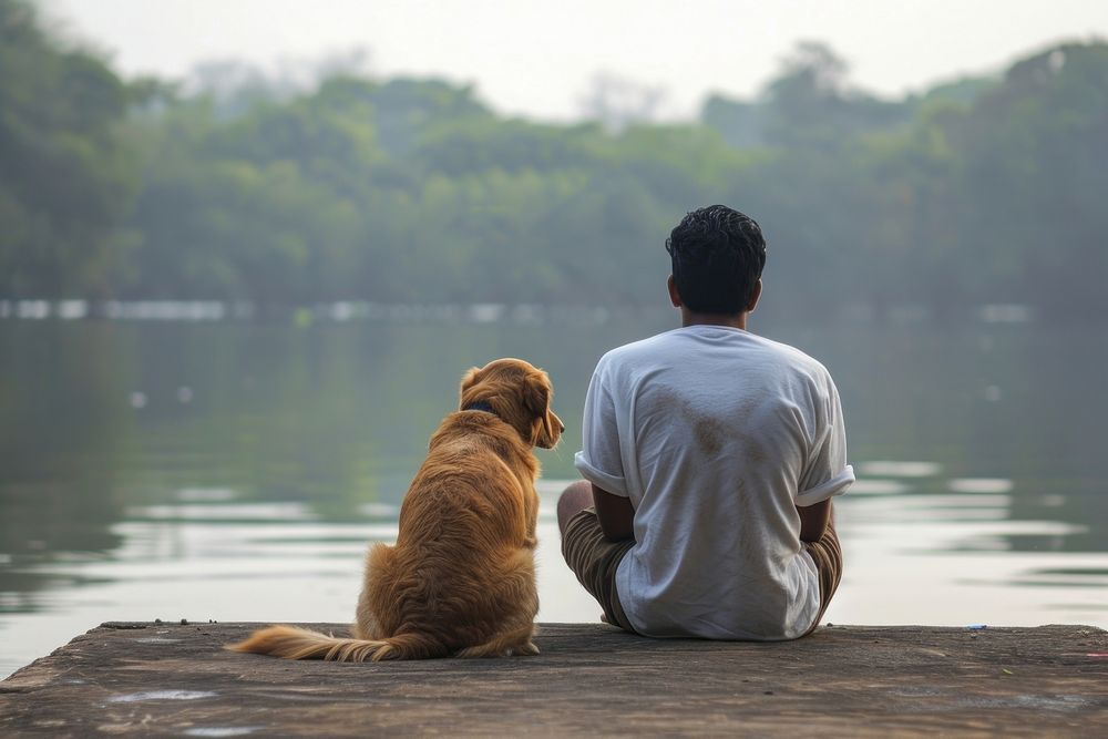 Indian man sitting with dog on jetty outdoors animal mammal.