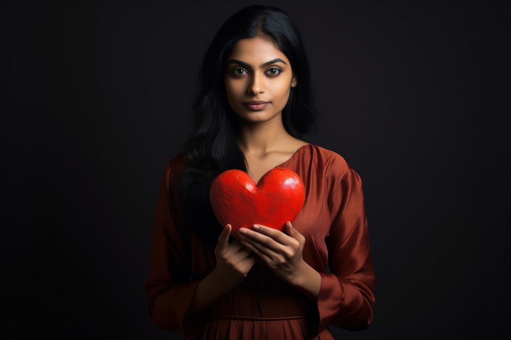 Indian woman holding red heart adult cross-legged hairstyle.
