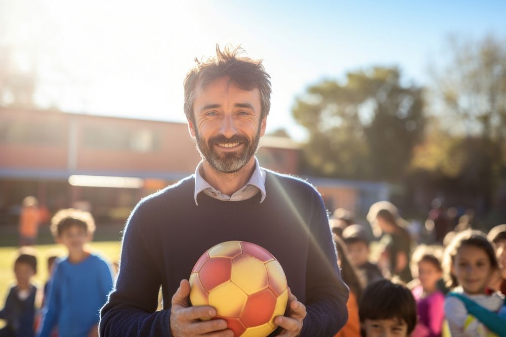 Argentinian teacher holding a football standing portrait sports.