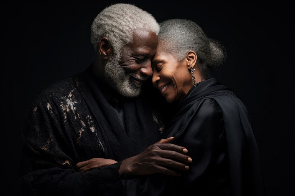 Black senior couple portrait hugging adult.